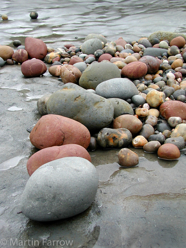 Pebbles-on-Rock 
 Coloured pebbled on rocky shore 
 Keywords: pebbles,shore,beach,coast,coloured