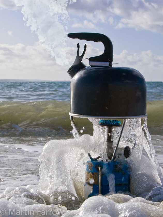 Boiling-The-Ocean 
 Boiling kettle on camping stove on beach 
 Keywords: kettle boil,steam,flame,wave,foam,shore,beach,sea