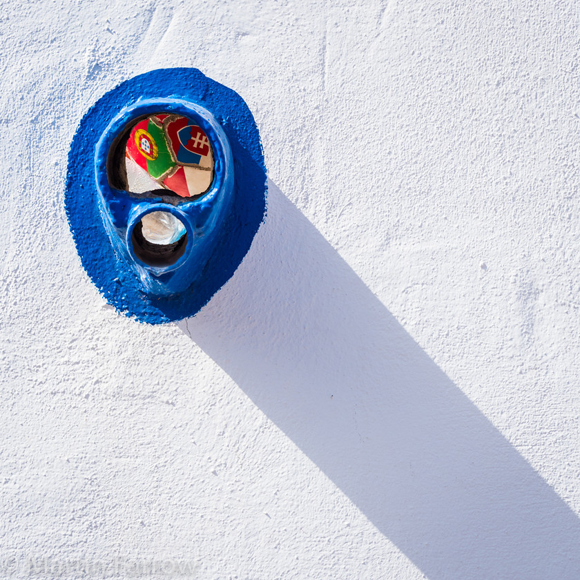 Trapped-Ball 
 White wall with blue drain and diagonal shadow 
 Keywords: Canaries, Gran Canaria, ball, blue, diagonal, drain, shadows, wall, white