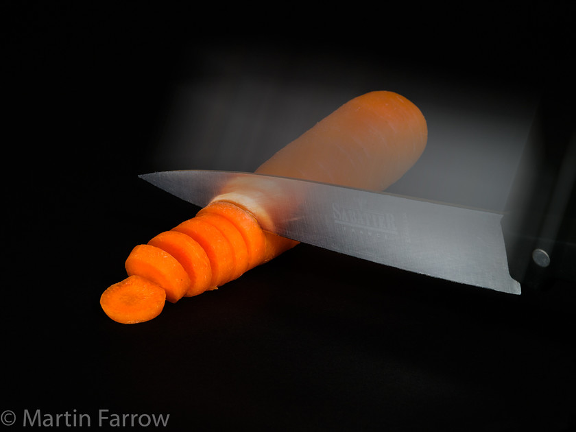 Chop 
 Carrot being chopped 
 Keywords: Food, kitchen, preparation, tools, utensils,carrot,knife,chop,action,cut,slice