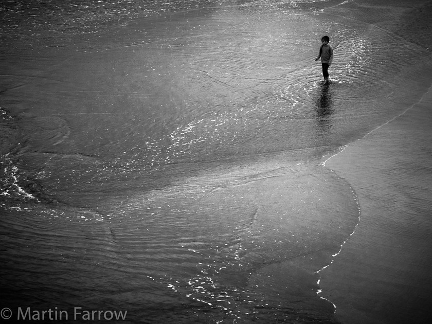 Paddling 
 Lone person on a sandy shore paddling in gently breaking waves, monochrome 
 Keywords: Cornwall, St Ives.coast, beach, edge, lone, monochrome, ocean, paddling, person, ripples, sand, sea, shore, waves