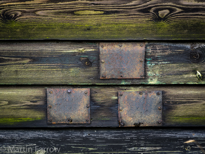 Patchwork 
 Metal patches on timber building 
 Keywords: Norfolk, Winterton on Sea, beach, coast, huts, timber,patch,wall,green,old,weathered