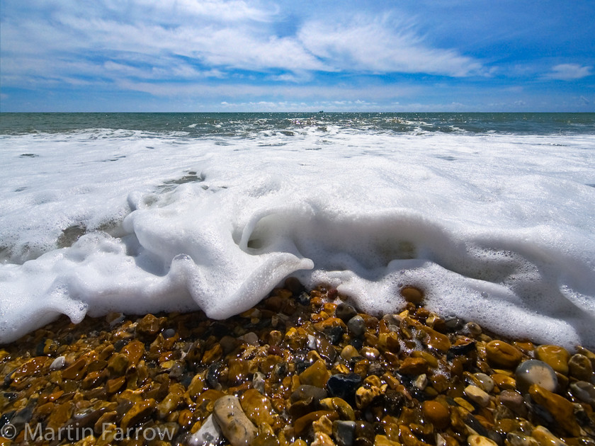 Dancing-Foam 
 Foam dancing over the shore 
 Keywords: beach, breaking, clouds, foam, shore, sky, waves,pebbles,sea,ocean,white