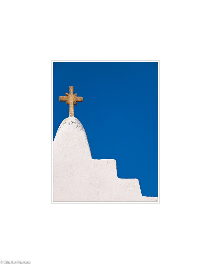 11 Cross 
 Stepped white wall with gold cross on top against blue sky 
 Keywords: ARPS panel fine art blue white simple abstract graphic architecture wall step cross gold sky church Santorini Greece island