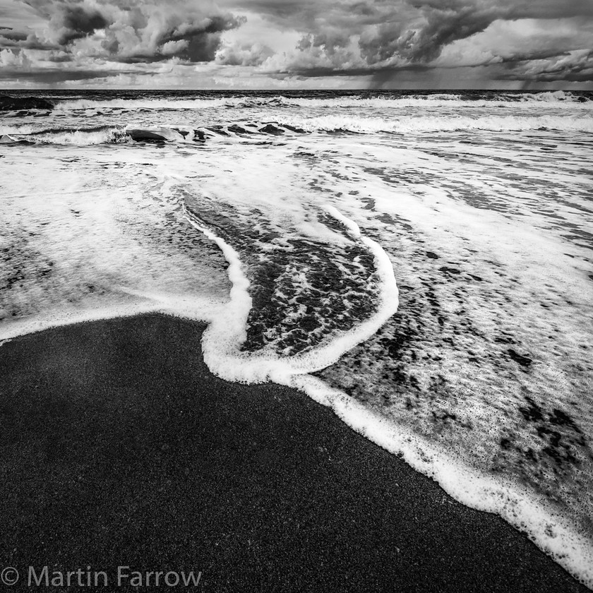 Storm-Brewing 
 Breaking waves on a beach with storm clouds in the background 
 Keywords: Bergi, Cefalu, Italy, Madonie, Sicily, beach, clouds, coast, foam, hills, landscape, ocean, sea, shore, storm, water, waves